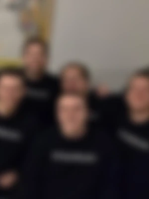 A deliberately blurred group photo of five people in matching black t-shirts
